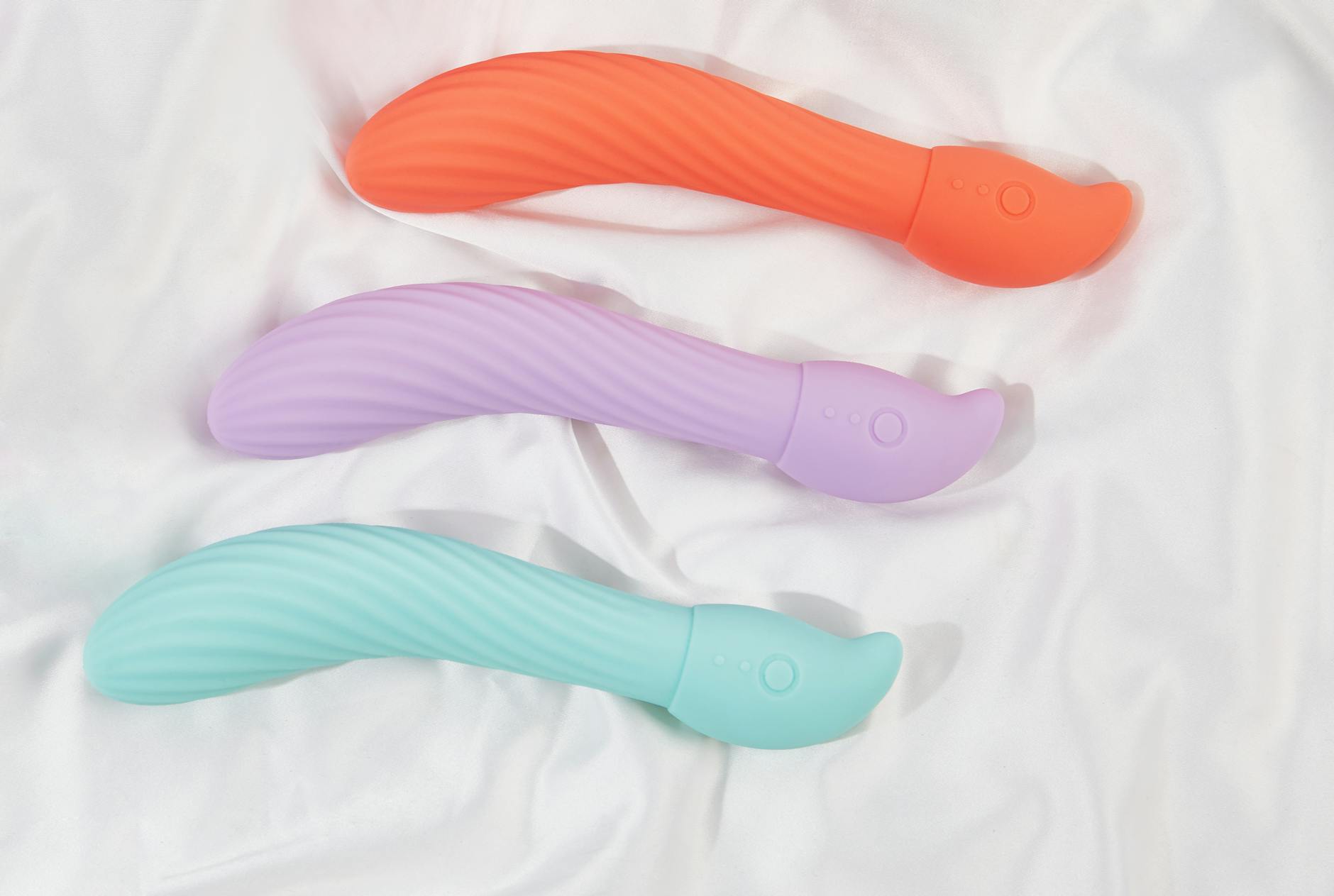 Three colorful vibrators arranged on white fabric, symbolizing safe choice and control