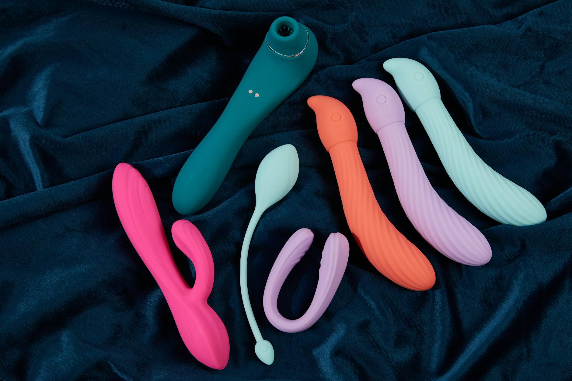 Pink vibrator on purple background with heart confetti and candles