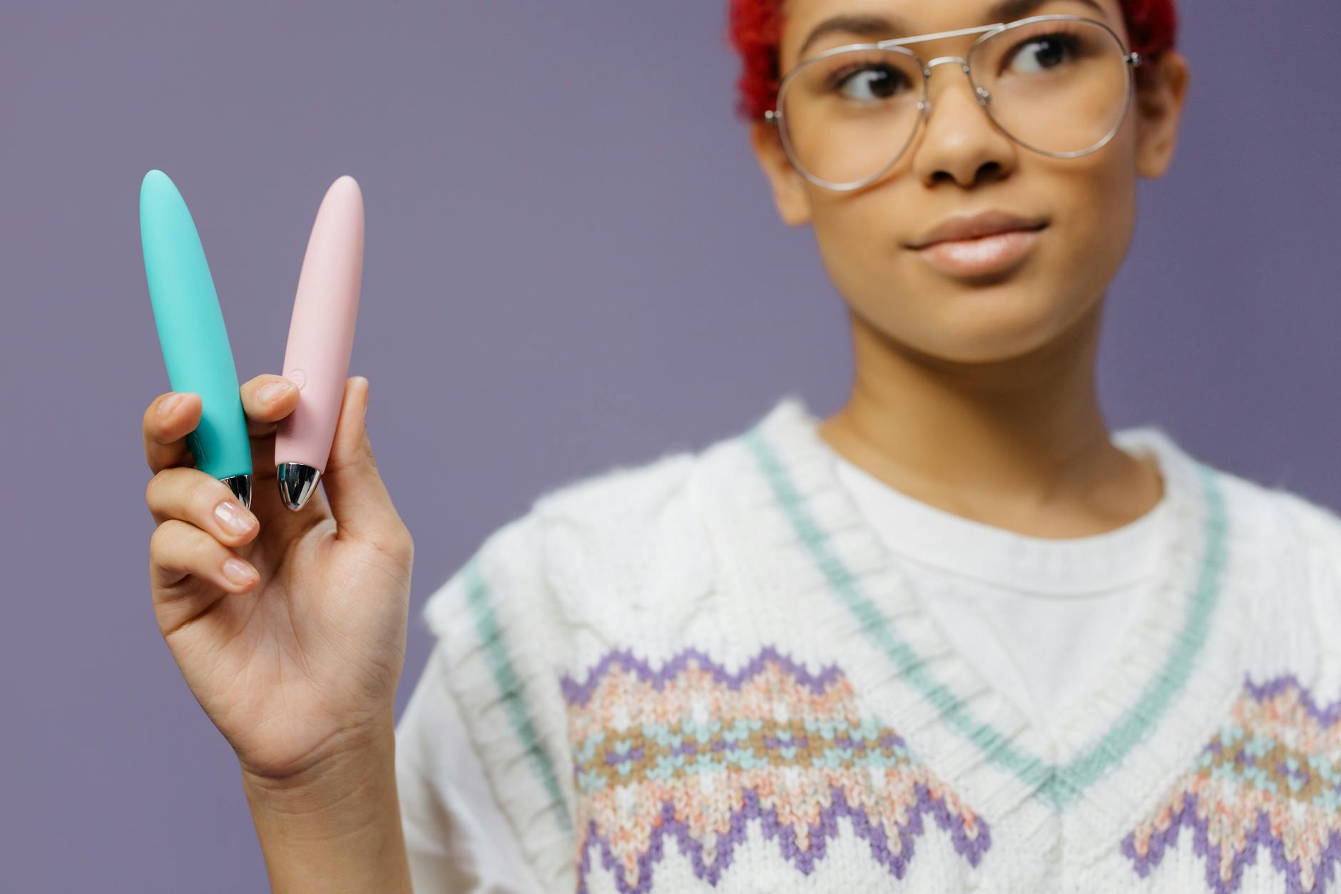 A woman with confidence explores pleasure tools against a vibrant purple background.