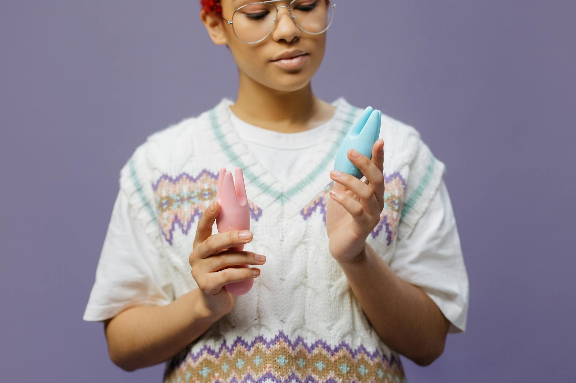 Woman holding vibrators and considering pleasure options in midlife